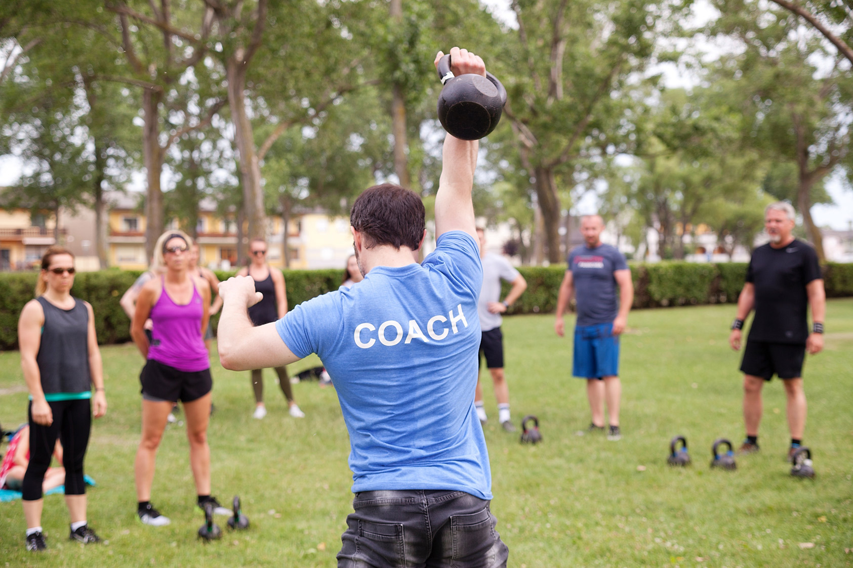 Fitnesscoach zeigt den Teilnehmern Übungen vor